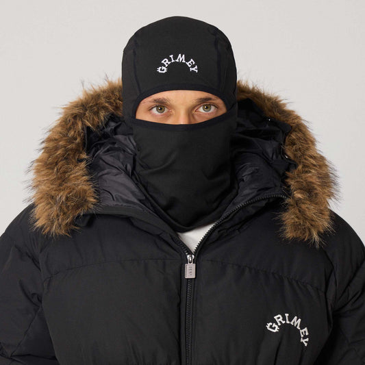 Balaclava negra The Infamous de la marca Grimey, diseñada para protección y estilo, con detalles en tejido ajustado y cobertura facial completa.