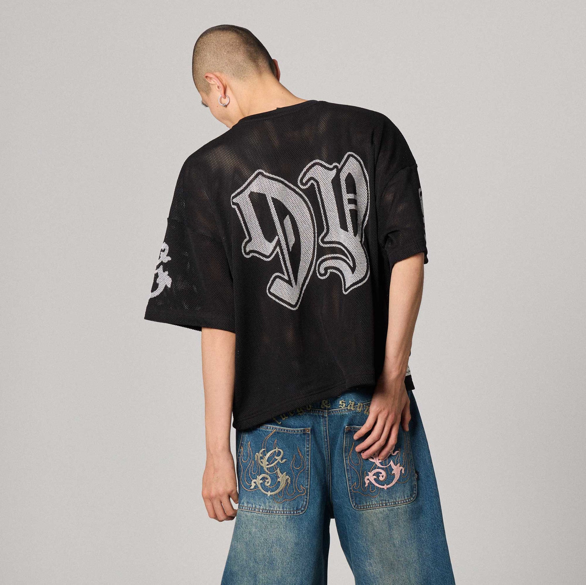 Camiseta negra de malla tipo boxy de la marca Grimey, estilo casual y moderno, con diseño de malla en la parte superior.