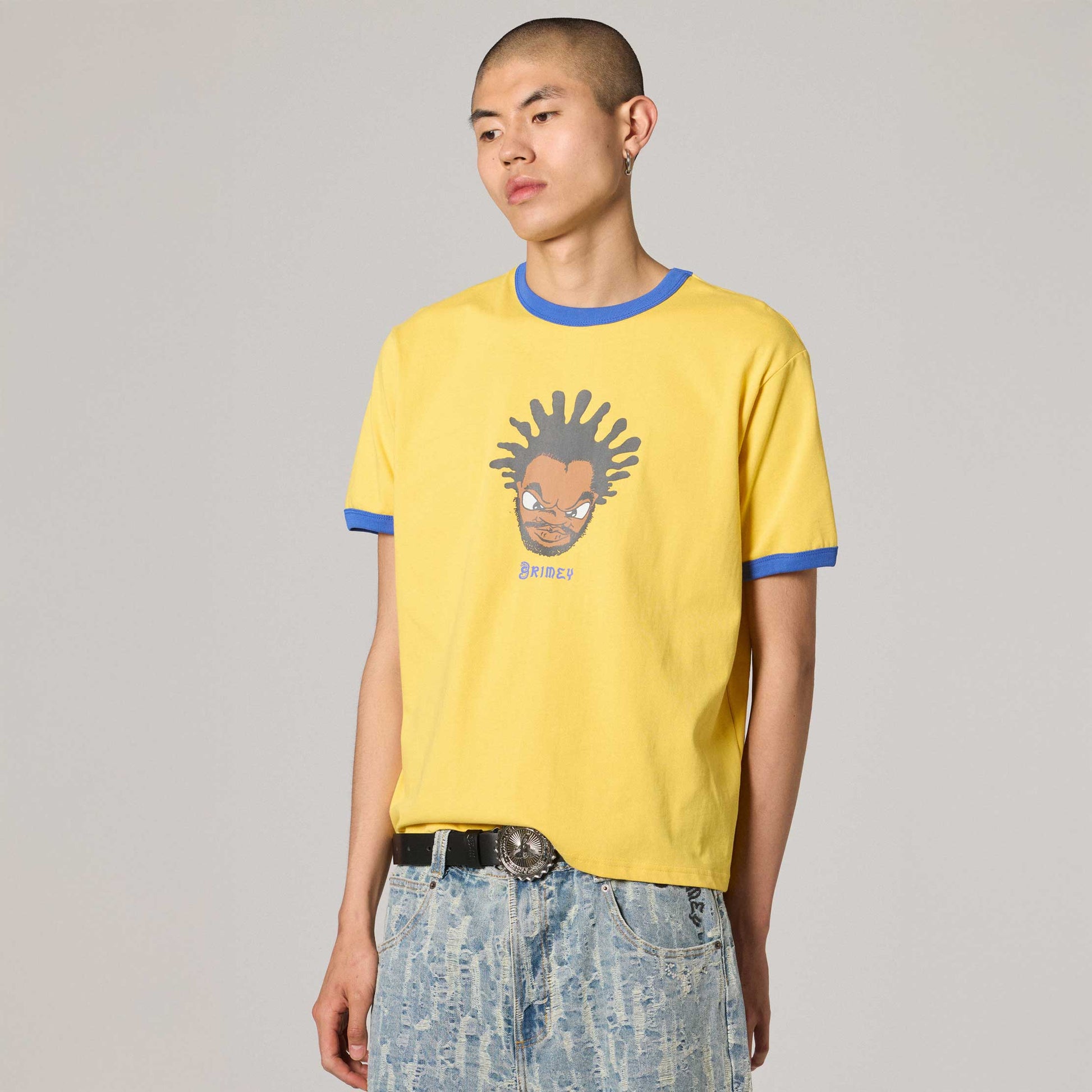 Camiseta Droppin Science Ringer amarilla de la marca Grimey, con cuello y mangas en contraste amarillo y blanco en un fondo neutro.