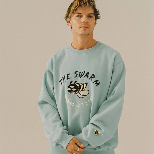 Sudadera azul de la colección The Swarm de DC Shoes x Grimey, con diseño en la parte frontal y logotipo de la marca.