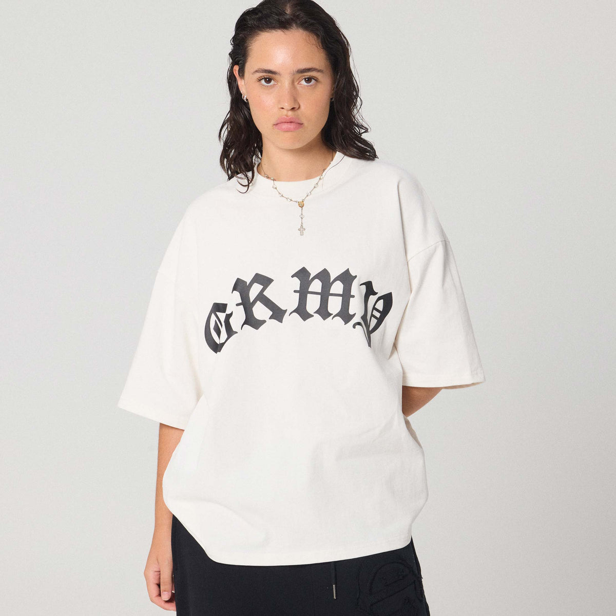 Camiseta boxy blanca con estampado "Rise Above" de la marca Grimey, vista frontal en estilo casual y moderno.