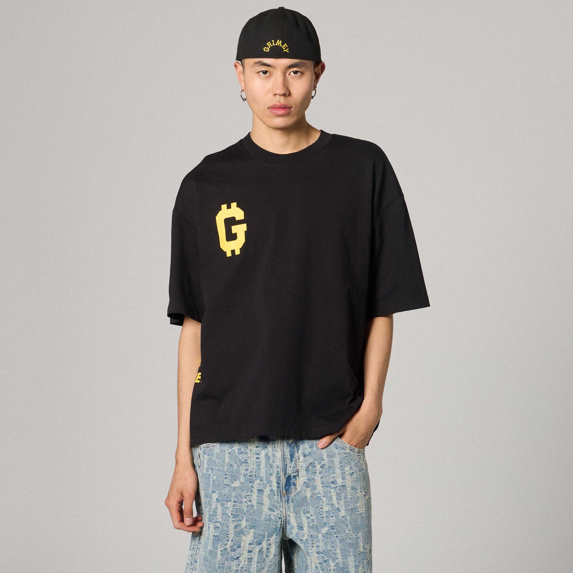 Camiseta negra de corte boxy de la marca Grimey con diseño Get Money, vista frontal y detalles de la prenda.