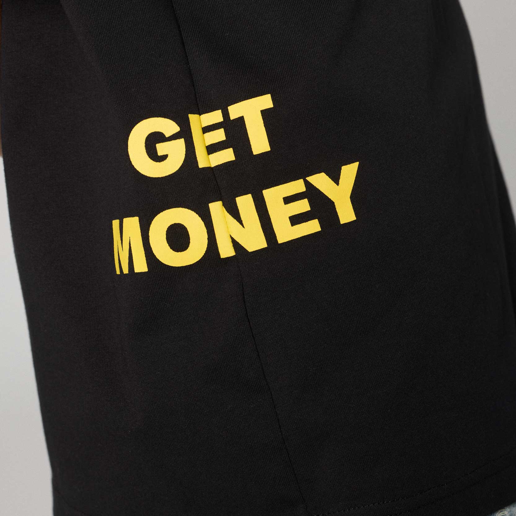 Camiseta negra estilo boxy de Grimey con texto "Get Money" en el frente, estilo casual y moderno, vista frontal.