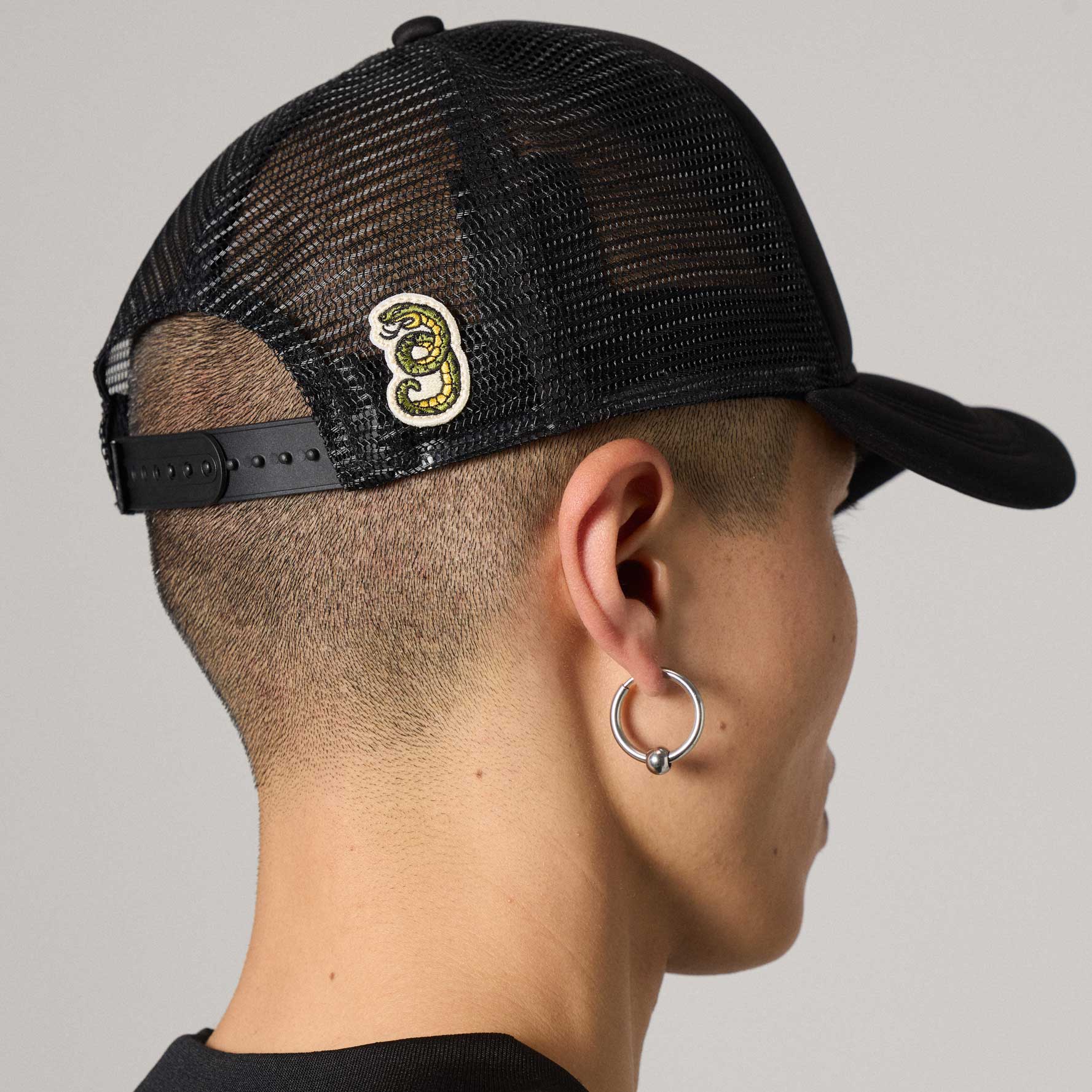 Gorra trucker negra de la marca Grimey con diseño Droppin Science, vista frontal en estilo casual y moderno.