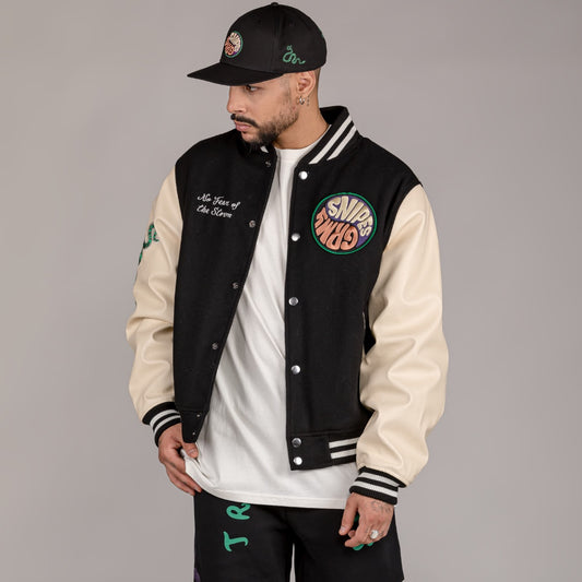Chaqueta de baseball negra Grimey "SNIPES X GRIMEY TRUE ROOTS" para otoño, vista frontal con diseño deportivo.